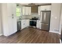 A renovated kitchen featuring white cabinets, stainless steel appliances, and modern countertops at 8977 Teal Ln, Jonesboro, GA 30236