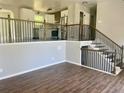 Beautiful open-concept living space with wood floors and iron and wood railing leading to an upstairs kitchen at 8977 Teal Ln, Jonesboro, GA 30236