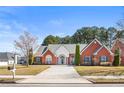 Charming single-story brick home with a manicured lawn, featuring an arched entryway and symmetrical window placement at 105 Glenmore Ln, Mcdonough, GA 30253