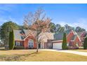 Inviting single-story brick home with manicured lawn, curved driveway, and symmetrical design elements at 105 Glenmore Ln, Mcdonough, GA 30253