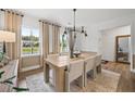 Elegant dining room with a wooden table, stylish chairs, and contemporary light fixture at 1636 Tide Mill Rd, Cumming, GA 30040