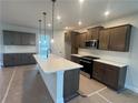 Modern kitchen with stainless steel appliances, white subway tile backsplash and a quartz countertop island at 1636 Tide Mill Rd, Cumming, GA 30040