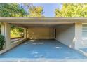 View of the carport with a painted concrete slab, neutral painted brick support columns, and an adjacent door at 8596 Timberlane Dr, Douglasville, GA 30134