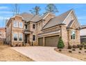 A spacious two-story brick home featuring an attached two-car garage and neatly arranged landscaping at 909 Sunny Meadows Lane, Marietta, GA 30062