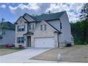 Two-story home featuring a brick facade, a two-car garage, and a well-maintained lawn at 556 Paden Ridge Way, Lawrenceville, GA 30044