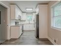 Modern kitchen featuring white cabinets, stainless steel appliances, granite countertops, and wood-look flooring at 2682 Cavalier Dr, Decatur, GA 30034