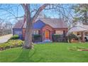 Charming brick home on a lush lawn, featuring an arched doorway, mature trees and manicured landscaping at 958 Winburn Dr, Atlanta, GA 30344