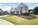 Inviting two-story home featuring a well-manicured lawn, stone accents, and a two-car attached garage at 415 Eldridge Dr, Suwanee, GA 30024
