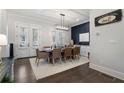 Bright dining room with a rustic table, seating for eight, and access to a patio with shuttered doors at 825 Maplewood Dr, Roswell, GA 30075