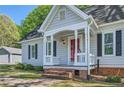 Charming single-story home with gray siding, black shutters, a red door and a covered brick porch at 3664 Bonnie Glenn Ln, Tucker, GA 30084