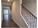 Hallway featuring a carpeted staircase and wood flooring, offering a view into the living room at 6615 Bluffview Dr, Douglasville, GA 30134