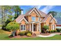 Beautiful brick home with a well-maintained lawn, showcasing classic architecture and inviting landscaping at 7430 Polo Hl, Cumming, GA 30040