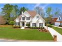 Charming two-story home with a well-manicured lawn and lovely landscaping at 7430 Polo Hl, Cumming, GA 30040