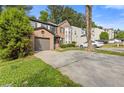 View of a two-story townhouse with a brick facade, driveway, and lush green landscaping at 1379 Vintage Pointe Dr, Lawrenceville, GA 30044