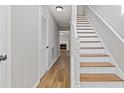 Bright hallway with hardwood floors, white trim, staircase, and a glimpse of a fireplace at 1379 Vintage Pointe Dr, Lawrenceville, GA 30044