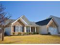 Inviting home exterior featuring stone accents, black shutters, well-maintained lawn, and attached garage at 3851 Bogan Mill Rd, Buford, GA 30519