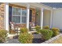 Cozy front porch with seating area surrounded by lush landscaping for relaxing outdoors at 3851 Bogan Mill Rd, Buford, GA 30519