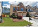 Well-maintained lawn leading to the brick front of this townhome with a two-car garage at 6270 Shiloh Woods Dr, Cumming, GA 30040