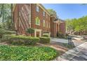 Brick townhome with manicured landscaping, featuring a charming entrance and attached garage at 7155 Roswell Rd # 15, Atlanta, GA 30328