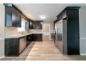 Modern kitchen featuring stainless steel appliances, granite countertops, and dark cabinets at 1171 Bailing Dr, Lawrenceville, GA 30043