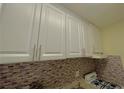 This kitchen features modern white cabinets and a tile backsplash at 2805 Ne Ne Expressway Ne # B-26, Atlanta, GA 30345