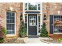 Elegant front door with glass panels, flanked by potted plants and stylish exterior lighting at 2898 Stockbridge Way, Dacula, GA 30019