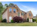 Charming brick house featuring a large garage, bench, manicured lawn, and beautiful windows at 2898 Stockbridge Way, Dacula, GA 30019