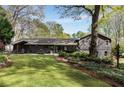 A lush backyard featuring a well-maintained lawn, mature trees, and an outdoor living area at 259 Dartmoor Cir, Atlanta, GA 30328