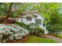 Quaint white brick house with lush landscaping and a charming front yard blooming with spring flowers at 648 Channing Nw Dr, Atlanta, GA 30318