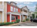 View of a red townhouse with inviting front entrances and parking available at 1797 Brookside Lay Cir, Norcross, GA 30093