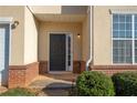 Inviting front entrance with a dark-colored door, brick accents, and manicured shrubbery at 2384 Coach Way, Jonesboro, GA 30236