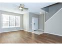 Open living room featuring hardwood floors, large windows, and a staircase, creating a bright and airy atmosphere at 2384 Coach Way, Jonesboro, GA 30236