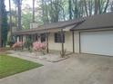 View of the front exterior with an attached garage and mature trees in the background at 4148 Silver Hill Ct, Snellville, GA 30039