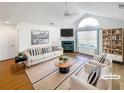 Bright, staged living room with vaulted ceilings, large window, fireplace, modern furnishings, and neutral color palette at 3824 Vineyards Lake Nw Cir # U16, Kennesaw, GA 30144