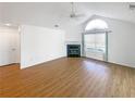 Empty living room featuring vaulted ceilings, large window, a fireplace, and wood-look flooring at 3824 Vineyards Lake Nw Cir # U16, Kennesaw, GA 30144