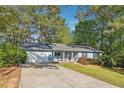 Single-story home with a two-car garage and a front lawn on a sunny day at 2341 Cedar Dr, Lawrenceville, GA 30043