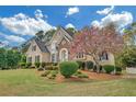 Charming home with a well-maintained lawn and a flowering tree, complementing the house's architectural style at 1405 Wilmington Way, Grayson, GA 30017