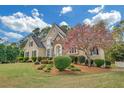 Charming two-story home with lush landscaping, decorative stone, and a blooming tree at 1405 Wilmington Way, Grayson, GA 30017