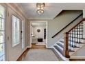 Inviting foyer showcases hardwood floors, a staircase with a dark wood banister, and decorative glass front door at 5023 Buckline Xing, Dunwoody, GA 30338