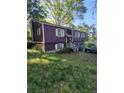 Angle view of a two-story home with a two-car garage surrounded by lush trees at 6150 Silver Spur Dr, Lithonia, GA 30058
