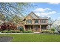 Charming two-story home featuring a stone and brick facade, a covered porch, and manicured landscaping at 322 Tupelo Tr Trl, Canton, GA 30114