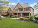 Traditional two-story brick home with a welcoming front porch and manicured lawn at 322 Tupelo Tr Trl, Canton, GA 30114