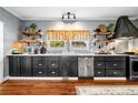 Modern kitchen featuring dark cabinets, stainless steel appliances, and floating wooden shelves at 4504 Union Hill Rd, Canton, GA 30115