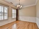 Dining room featuring hardwood floors, two windows, and elegant chandelier at 1668 Sabastian Ne Pt, Atlanta, GA 30329