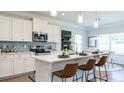 Modern kitchen featuring white cabinets, stainless steel appliances, and a quartz countertop island with seating at 233 Silver Leaf Trce, Douglasville, GA 30134