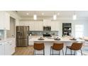 Bright kitchen featuring white cabinets, stainless steel appliances, and a quartz countertop island with seating at 233 Silver Leaf Trce, Douglasville, GA 30134