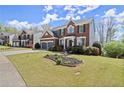 Lovely two-story brick home with a two-car garage and manicured front yard landscaping in a neighborhood at 3950 Almandine Way, Cumming, GA 30040