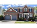 Lovely two-story brick home featuring an attached two-car garage and manicured front yard at 3950 Almandine Way, Cumming, GA 30040