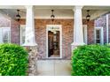 Charming entrance with brick pillars, stone accents, and elegant lighting fixtures at 4620 Westgate Dr, Cumming, GA 30040