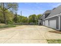 Expansive driveway leading to a three-car garage, complemented by the home's exterior and surrounding greenery at 1350 Blackwell Rd, Marietta, GA 30066